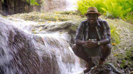 African traveler man sitting and relaxing freedom with waterfall.16:9 styleの写真素材