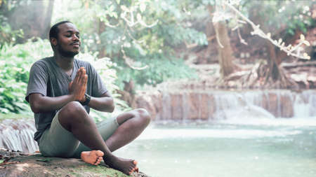 African man meditate spiritual peaceful praying and wishing in green natureの写真素材
