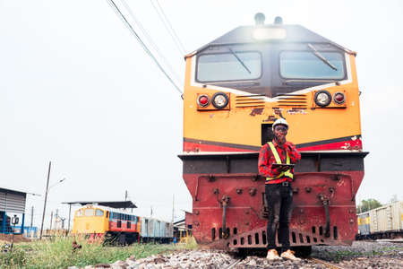 African engineer   control a the train on railway with using tablet and talking by radio...