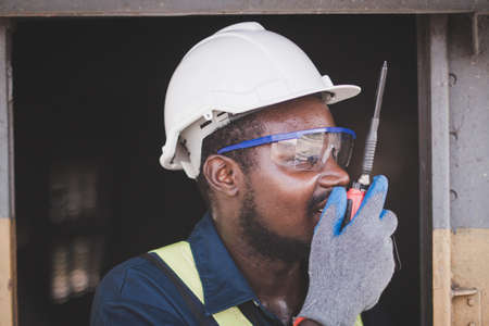 African male engineer control a the with talking by radio communication or walkie talkieの写真素材