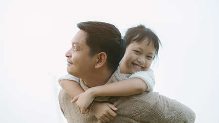 Father carrying his daughter on his back with love.Concept of fathers day