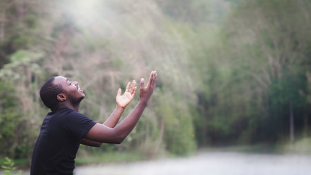 African man praying for thank god in the green nature backgroundの写真素材