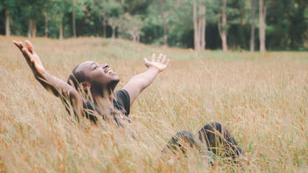 Freedom african man lying on the field in beutiful meadow.Happy and Enjoy Nature Concept