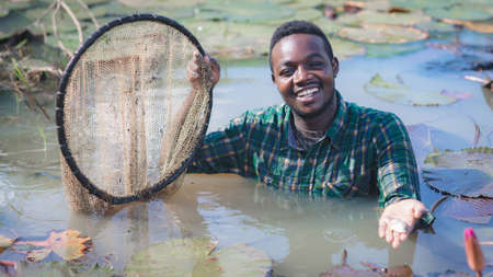 African farmer carry nets used to catch fish on his farms.Agriculture or cultivation conceptの写真素材