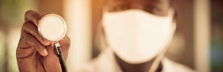 African doctor  holding stethoscope and wearing face maskの写真素材