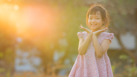 Asian happiness little girl receives miracle sun rays from the skyの写真素材