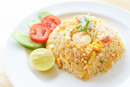 Fried rice with shrimp on the white dish on wooden tableの写真素材