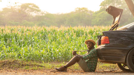 African tourist man sit happily taking camera in the back of their cars in the sunset timeの写真素材