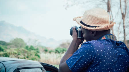African tourists stand happily photographing mountains and landscapes.Adventure travel conceptの写真素材