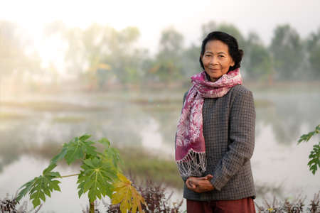 Happy asian elderly senior smile with the nature farm in background, Lifestyle of Asian old women conceptの写真素材