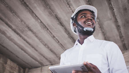 African architects engineer man with tablet work together in the inside the construction building siteの写真素材
