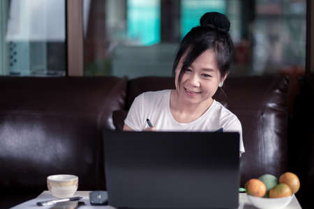 Woman works from home with using a laptop computer during lockdown or state quarantineの写真素材