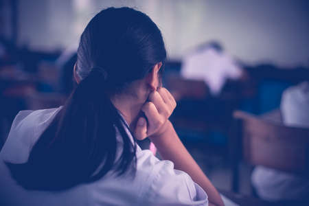 Tired uniform students sleeping in a exam test in classroom with stressの写真素材