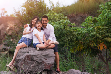 Happy family taking photo  on the rock mountain with sunset.Concept of family and travelの写真素材