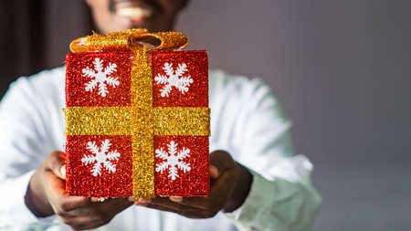 African man showing a gift box for christmas with smile and happyの写真素材