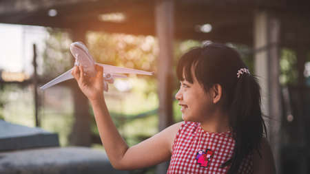 Little girl playing with a toy airplane with smile and happy.Concept of toy , imagination and creativityの写真素材