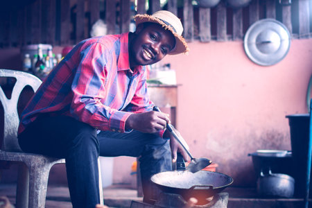 Smile Indigenous African man cooking in a rural kitchenの写真素材