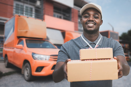 African delivery man holding a box package and cardboard.Concept of quarantine delivery serviceの写真素材