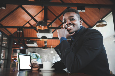 African business man using tablet and having a happy time with good idea thinking in coffee shopの写真素材