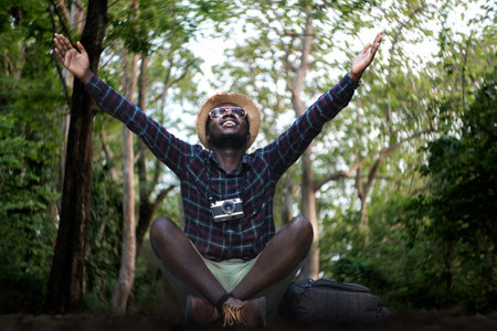 Freedom african traveler man with camera for taking photo and travel in wild trip hiking during vacation,Adventure travel conceptの写真素材