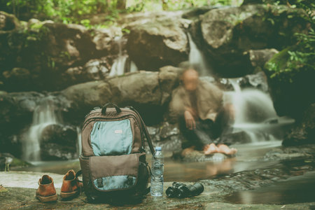 Adventurous traveler take off the shoes, drop their backpacks and telescopes to relax inside the...