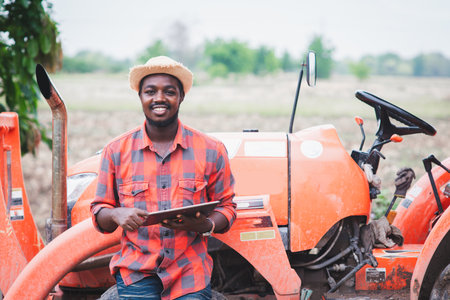 African farmer in hat using tablet at agriculture field.Cultivation conceptの写真素材