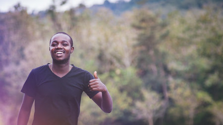 African man standing in nature forest and lake with smile and happiness.Concept about nature fertility and relaxationの写真素材