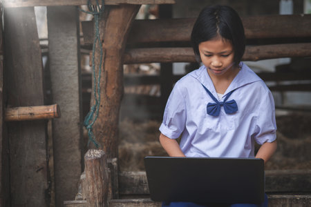Asian girl watching at screen of laptop computer. Students in rural area study online.Concept of Happiness life styleの写真素材