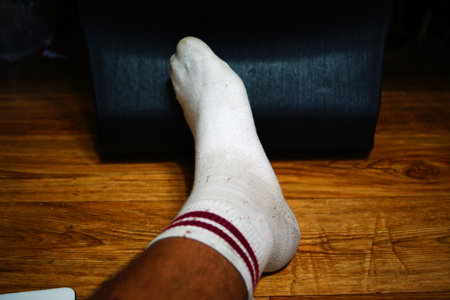 Legs of a man in socks on a wooden floor. Close-up.