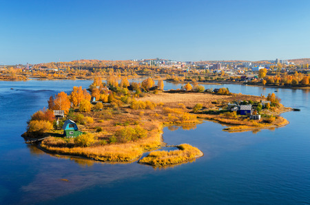 Autumn sunny island in the city of Irkutsk on the Angara River. View from the new bridge.の写真素材