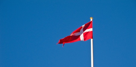 Dansih flag in the wind, dannebrog, against blue skyの写真素材