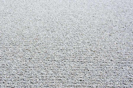 Background of gravel arranged in lines in a stone garden of a zen buddhist templeの写真素材