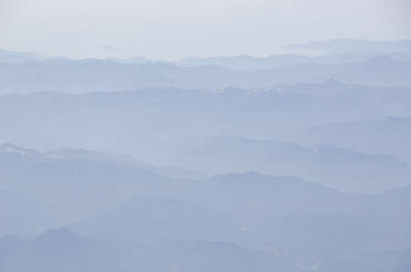 Mountain landscape with fog and sunshine, outline of mountainsの写真素材