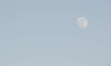 Almost full moon on a blue sky in the afternoonの写真素材