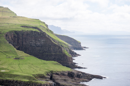 Landscape on the Faroe Islands with cliffs blue ocean and green grass on Mykinesの写真素材