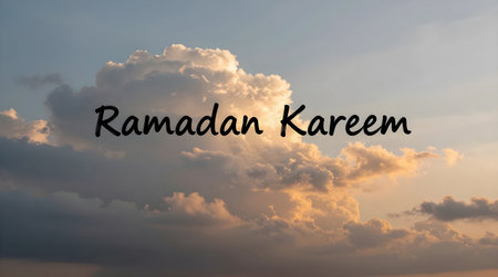 A serene sky with clouds illuminated by the sun at sunset with the text Ramadan Kareem written in blackの素材