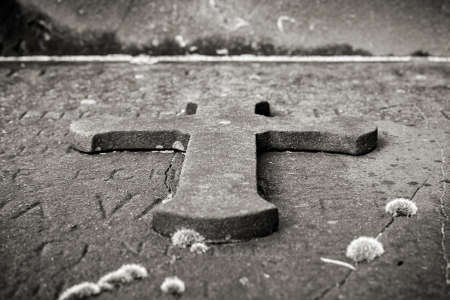 A stone cross on an old mossy grave  black and white の写真素材