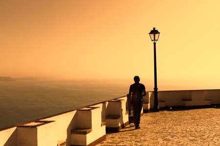 NAZARE, PORTUGAL - MAY 17, 2018.  A toutist enjoys the view from the Miradouro do Nazare at sunset.のeditorial素材