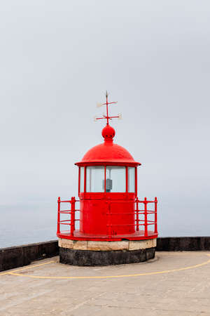 The red lighthouse lamp room on top of the Farol of Nazare in the mistの写真素材