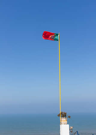 Portuguese flag photographed against a blue skyの写真素材