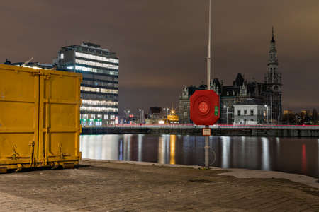 Antwerp, Belgium - February 5, 2020: A life buoy with the loodswezen - pilotage - building in the...
