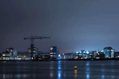 Temse, Belgium - March 11, 2020: The Flemish town of Temse by night. The old crane of the former Boelwerf shipping yard on the left.のeditorial素材