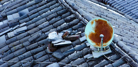 Old satellite dish on the broken roof.の写真素材