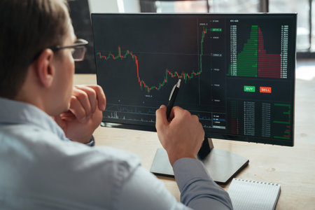 Financial analyst and trader examining attentively investment graph trying to predict money flowの写真素材