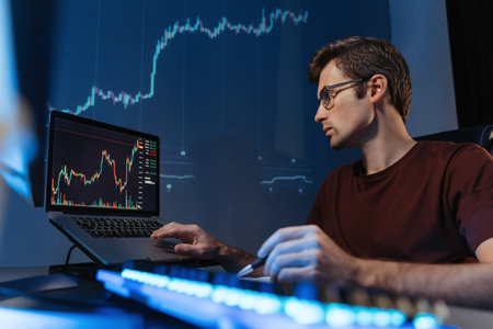 Financial crypto expert working online at home office, analyzing candlestick chart on laptop screenの写真素材
