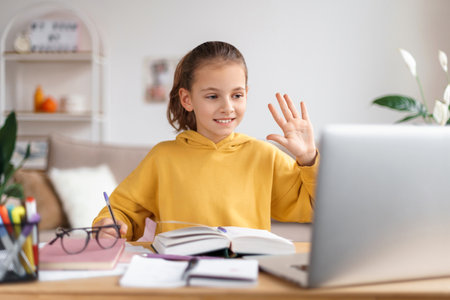School girl having online lesson at home via laptop webcam