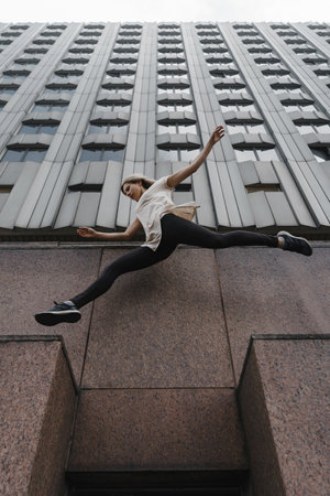 Young sporty woman doing parkour in cityの写真素材