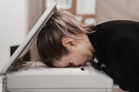 Businesswoman sleeping on printer at office. Overworked womanの写真素材