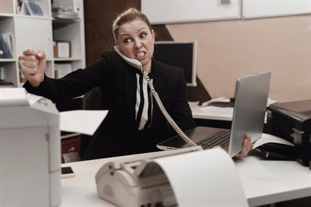 Office worker stressed. Overworked concept. Angry furious office womanの写真素材