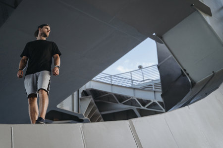 Portrait of freerunning athlete standing on the edge metal construction. Looking at place for your advertiseの写真素材